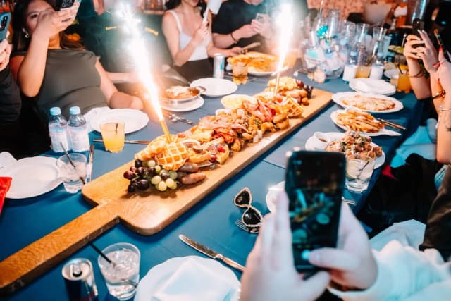 Guests photographing brunch platters and sparklers at LAVO Party Brunch in Las Vegas
