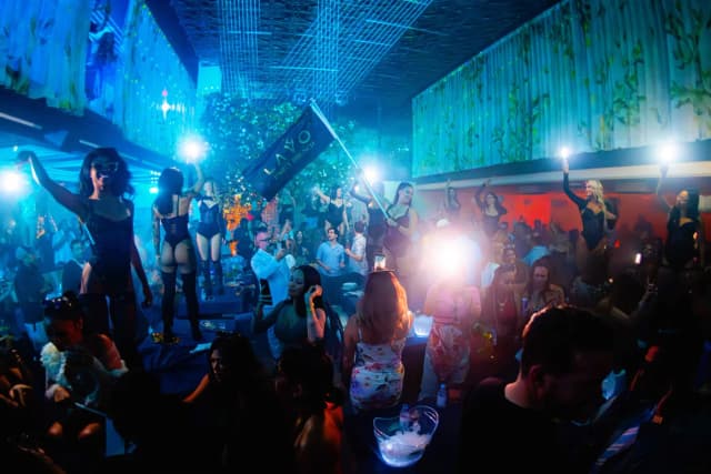 Guests and dancers celebrating under blue lights at LAVO Party Brunch in Las Vegas