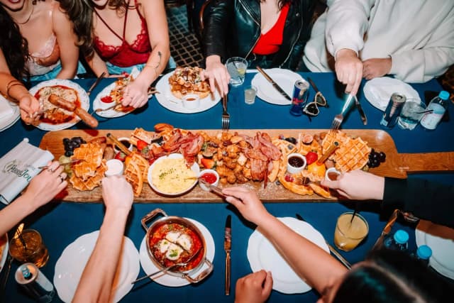Brunch dishes and drinks shared around a table at LAVO Party Brunch in Las Vegas